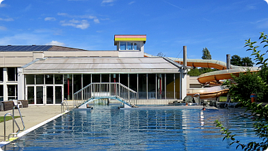 Freibecken und Wasserrutsche in Pinkafeld, im Hintergrund das Hallenbad ...