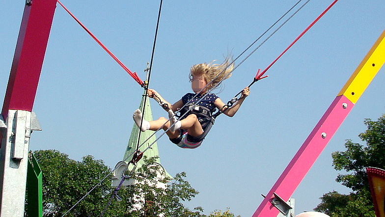 Ein Mädchen springt am Bungee-Trampolin