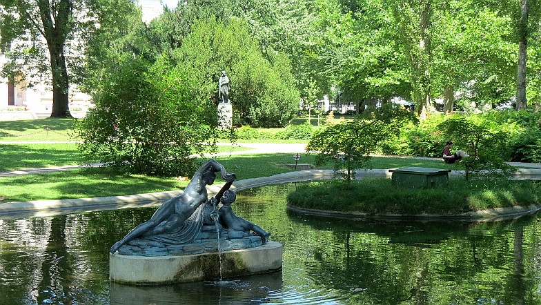 Der Liechtensteinpark in Wien, Alsergrund, Brunnennymphe mit Putto, im Hintergrund eine Statue des Raffael ...